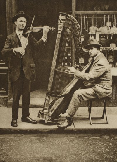 Street musicians: a harpist and violinist by English Photographer